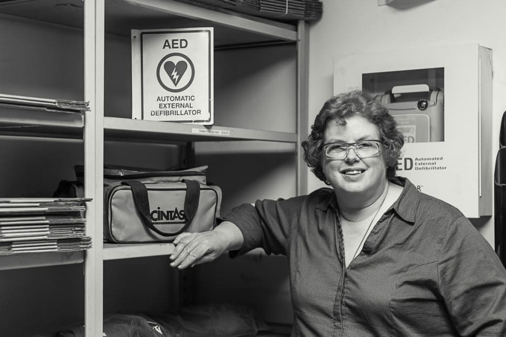Sharon-Safety Post-15 Black and white portrait of smiling woman posing with shelves